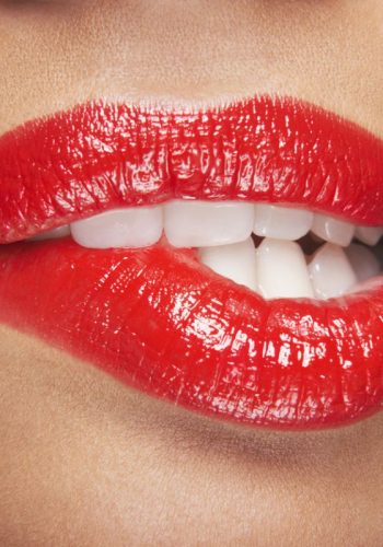 Closeup of sensuous woman biting red lips